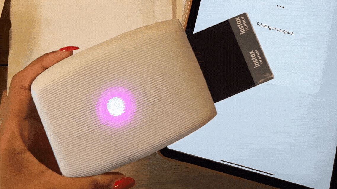 Gif of Instax mini printer with polaroid being printed
